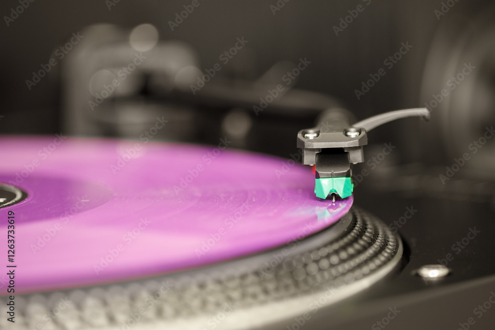 Giradischi, vista sulla testina. Disco musicale in vinile di colore viola.