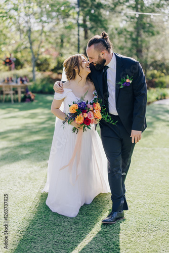 In a beautiful garden, a joyful bride and groom capture a heartfelt moment, celebrating their wedding with family and friends. Their smiles reflect the joy of the occasion and the promise of forever