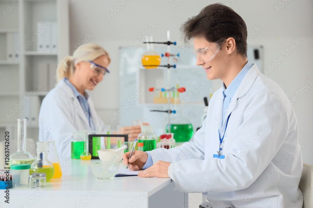 Male chemist working at table in laboratory Male chemist working at table in laboratory