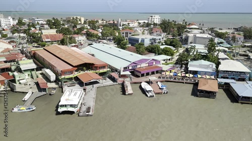 Drone hovers over water where Haulover Creek meets the gulf, facing water taxi and cruise port terminal on sunny morning in Belize City photo