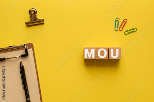 There is wood cube with the word MOU. It is an abbreviation for Memorandum of Understanding as eye-catching image. photo