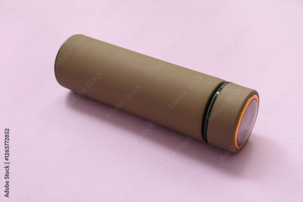 Brown modern thermos on lilac background Brown modern thermos on lilac background