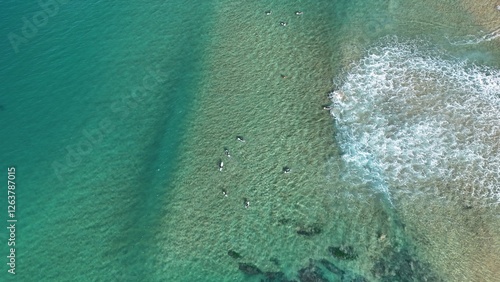 Drone shot aerial view at a beach and surfers waiting to catch the next wave in summer in Australia 