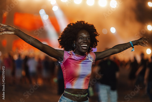 Fotografie Enthusiastic young woman enjoying live music at night festival