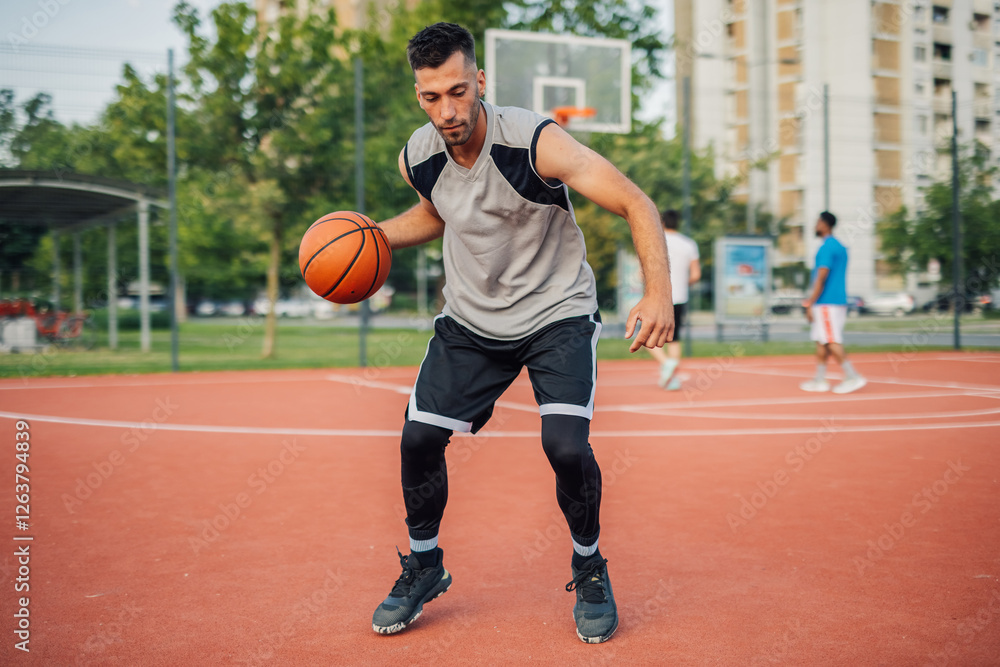 Basketball player dribbling ball on court during a game Basketball player dribbling ball on court during a game