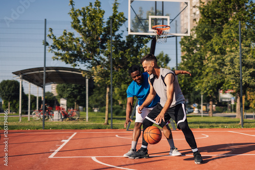 Two male basketball players defending during a game outdoors photo