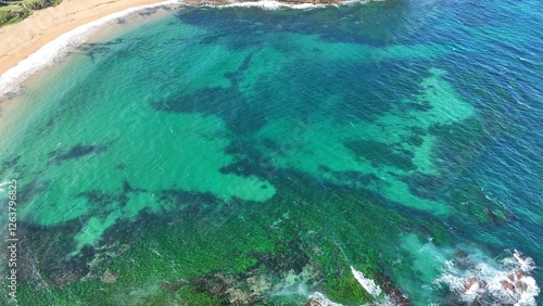 Drone shot aerial view of a beautiful turquoise water and reef near a beach in summer in Australia 