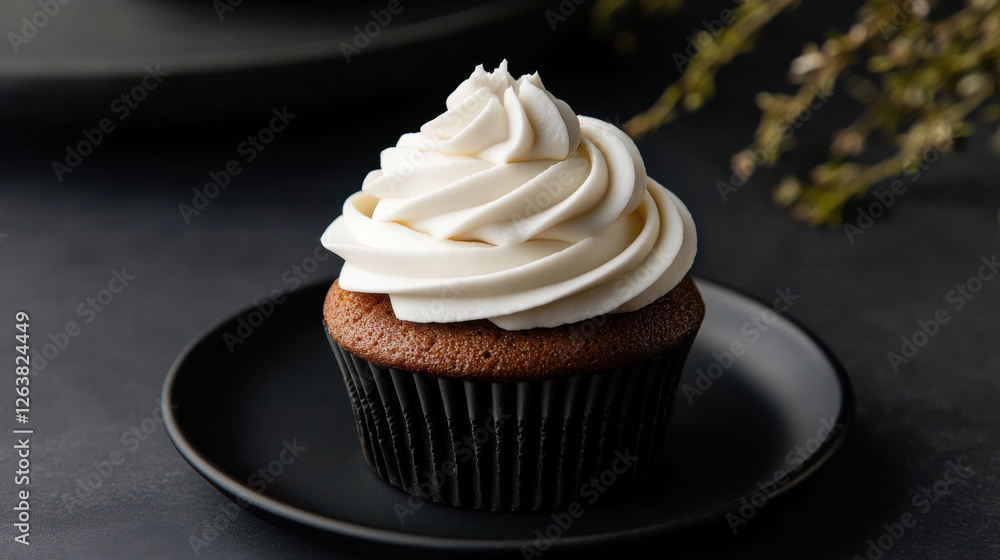 minimalist cupcake with smooth white frosting on dark plate minimalist cupcake with smooth white frosting on dark plate