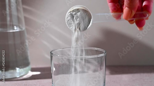 Amino acid food supplement, creatine powder in a measuring scoop and plastic jar