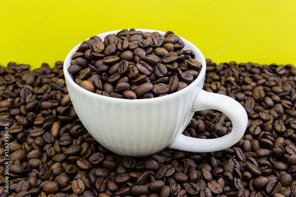 A white coffee cup is filled with coffee beans A white coffee cup is filled with coffee beans