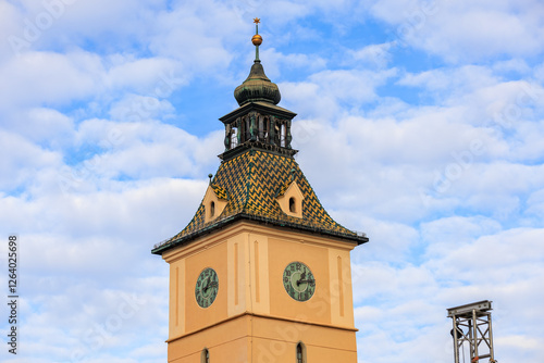 A tall clock tower with a steeple and a clock on each side