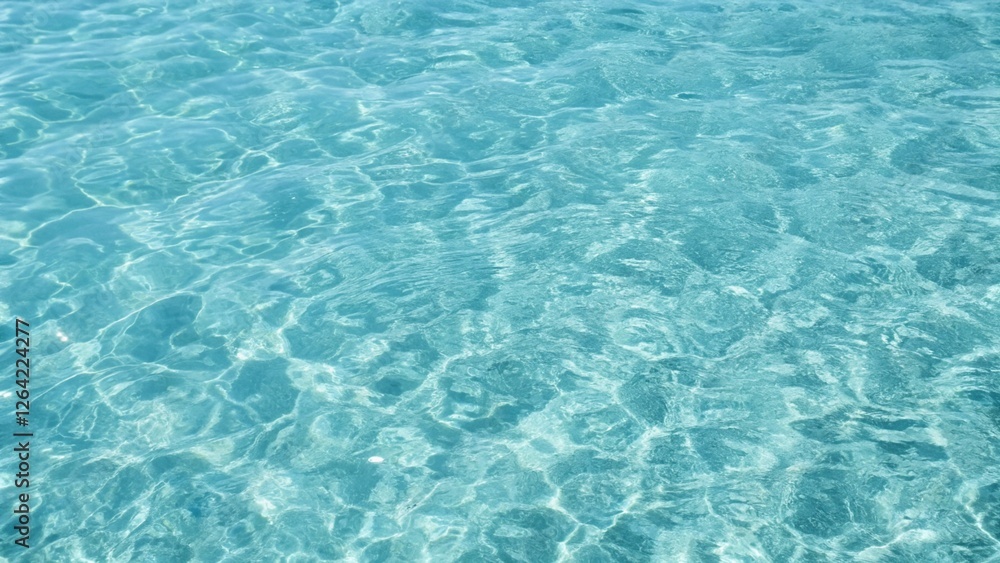 Blue ripped seawater in a swimming pool. Crystal clear ocean lagoon bay turquoise blue azure water surface, closeup natural environment. Tropical Mediterranean beach water background Blue ripped seawater in a swimming pool. Crystal clear ocean lagoon bay turquoise blue azure water surface, closeup natural environment. Tropical Mediterranean beach water background