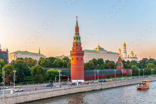 View of Kremlin with Vodovzvodnaya tower, Grand Kremlin Palace from repaired Bolshoy Kamenny Bridge in Moscow city on sunny summer day. Cruise ship sails on the Moscow river