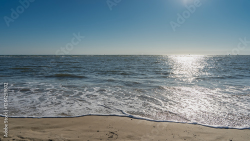 Seascape. Delicate foam of waves on a sandy beach. A sunny path on the surface of the water. The blue ocean. Azure clear sky. Copy  space. Madagascar. Morondava. Mozambique Channel. photo