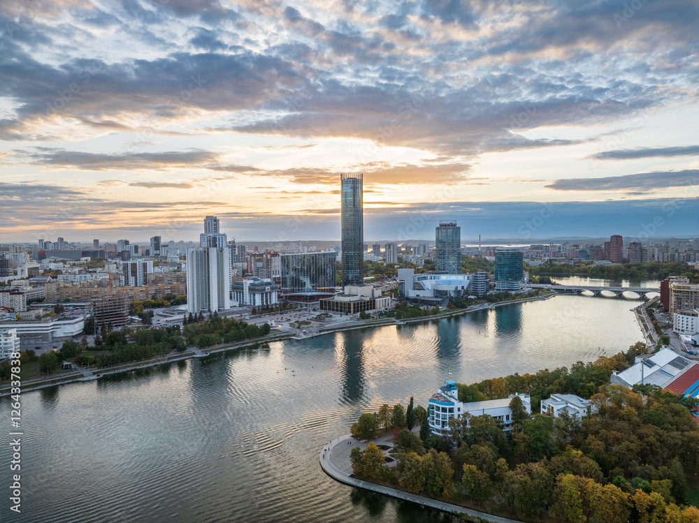 Fototapeta premium Yekaterinburg city and pond aerial panoramic view at summer or early autumn sunset. Night city in the early autumn or summer.