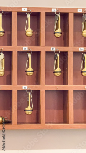 Lobby key rack with vintage keys, hotel nostalgia, hospitality industry decor, warm wooden accents photo