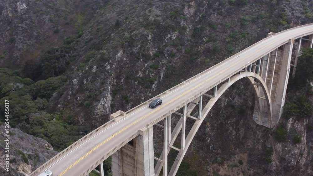 Rotation drone shot of a bridge between mountains with cars driving. Rotation drone shot of a bridge between mountains with cars driving.