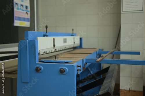 Fotografi A sturdy blue foot shear machine in a printmaking workshop, designed for precise