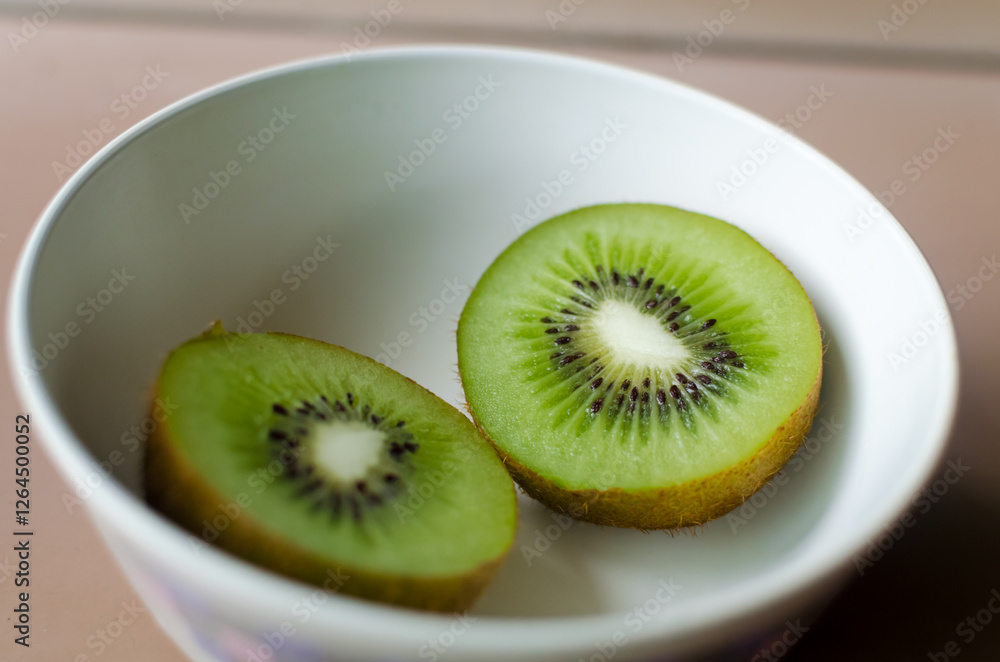 A closeup of a sliced kiwi fruit in a white bowl A closeup of a sliced kiwi fruit in a white bowl
