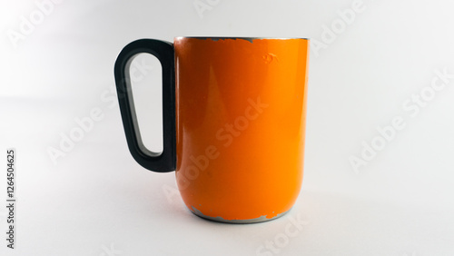 an orange cup whose paint has started to peel off, isolated on white