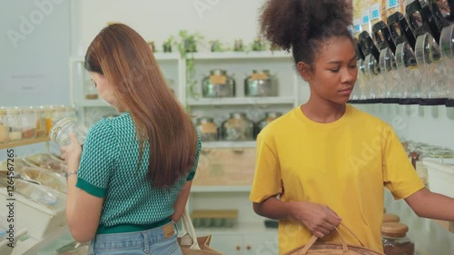 Female customer fills cereal foods in a glass jar, lever the reusable container on refill store shelves, zero-waste and plastic-free grocery, environment-friendly, sustainable lifestyles.
