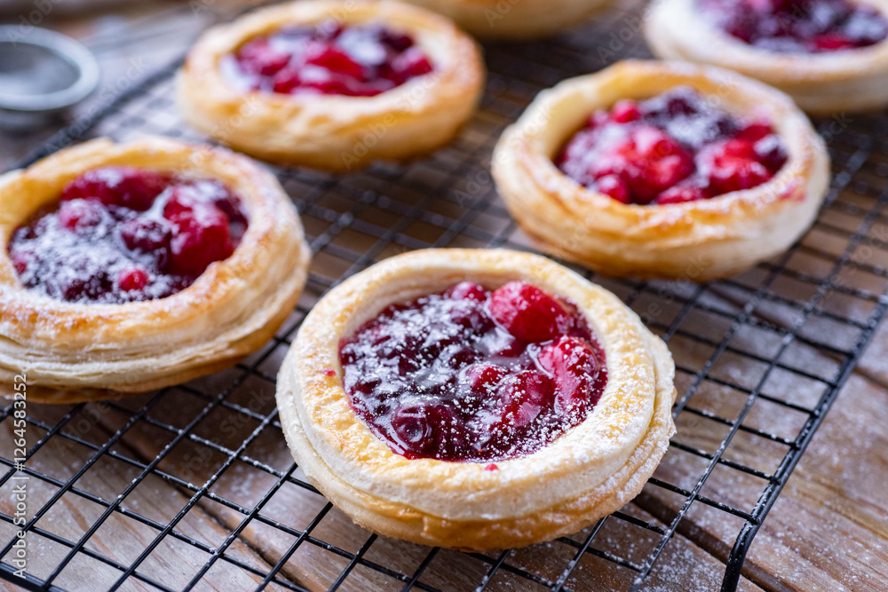 Cheesecakes with berries on a wooden table. Cherry buns for breakfast. Buns with strawberries for dessert. Pies with berries. Close-up Cheesecakes with berries on a wooden table. Cherry buns for breakfast. Buns with strawberries for dessert. Pies with berries. Close-up