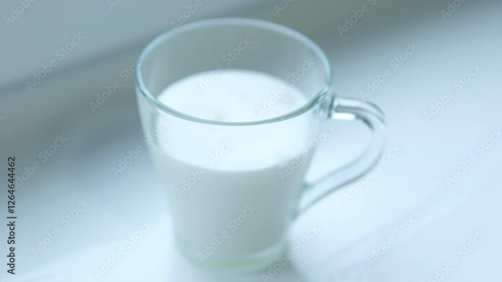 Pouring milk in glass from a bottle on a light neutral background with space for text, copy space. Glass of milk in slow motion. Pouring milk in glass from a bottle on a light neutral background with space for text, copy space. Glass of milk in slow motion.