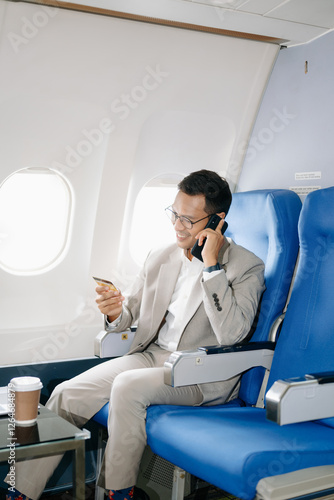 Asian man sitting in a seat in airplane and looking out the window going on a trip vacation travel concept. photo