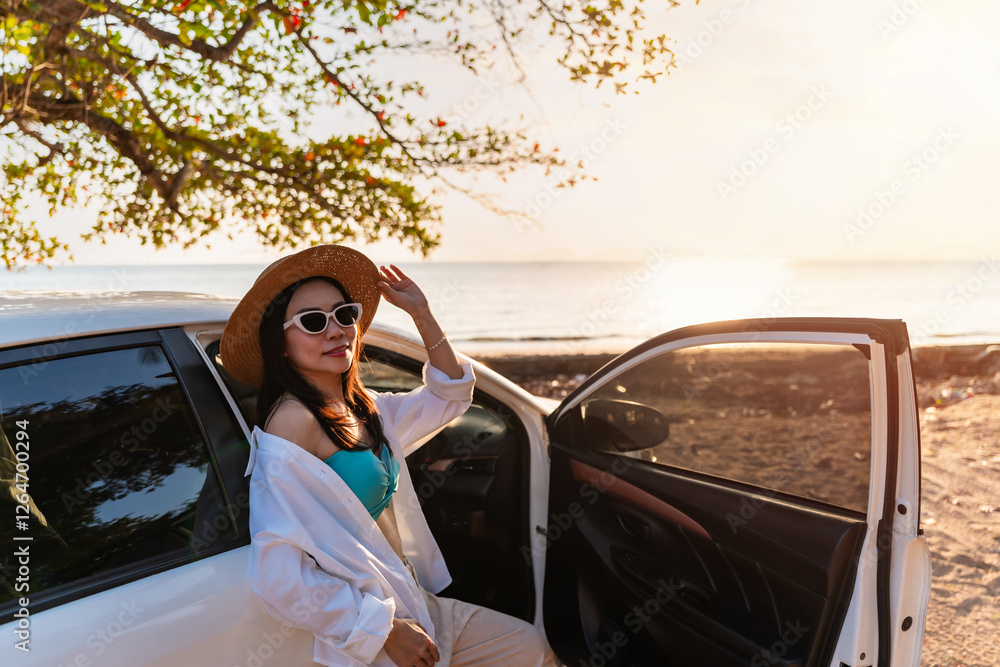 Happy young woman relaxing and enjoying watching a beautiful sunset at the beach, Road trip on summer vacation concept Happy young woman relaxing and enjoying watching a beautiful sunset at the beach, Road trip on summer vacation concept
