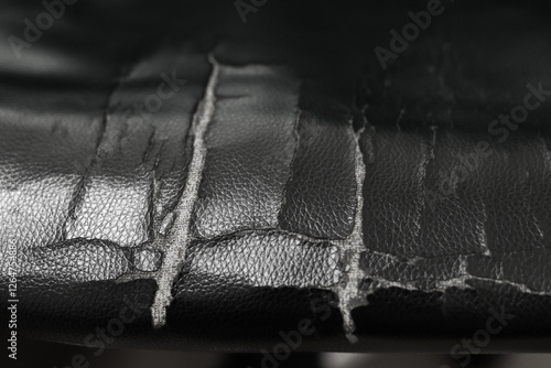 The leather material is torn. Tear damaged old leather brown sofa or chair .background. close up. copy space. High quality photo