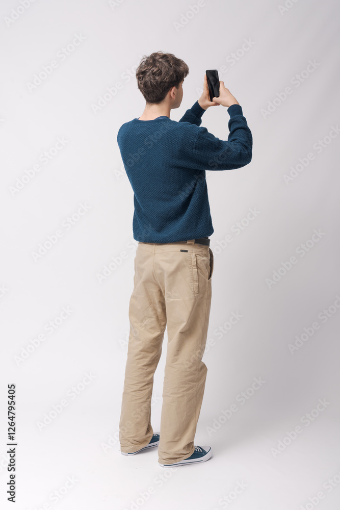 Teenager taking pictures with his smartphone Teenager taking pictures with his smartphone