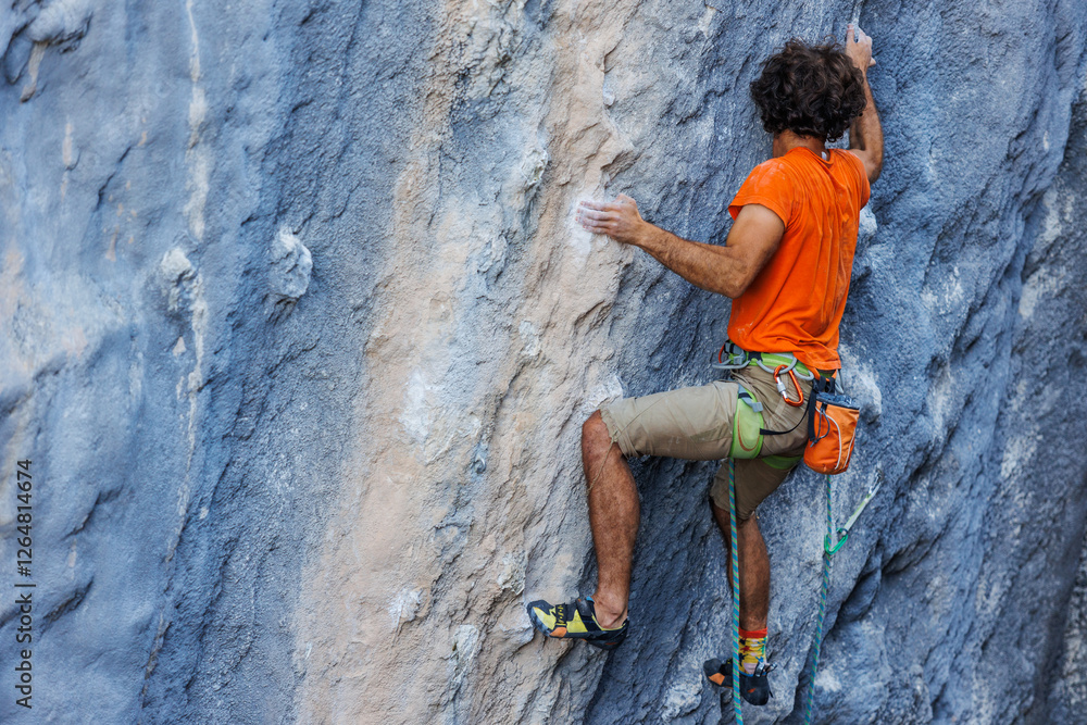 rock climber climbs on a rock. A strong man climbs a rock. Strong muscles. Endurance and strength training, man doing extreme sports. rock climber climbs on a rock. A strong man climbs a rock. Strong muscles. Endurance and strength training, man doing extreme sports.