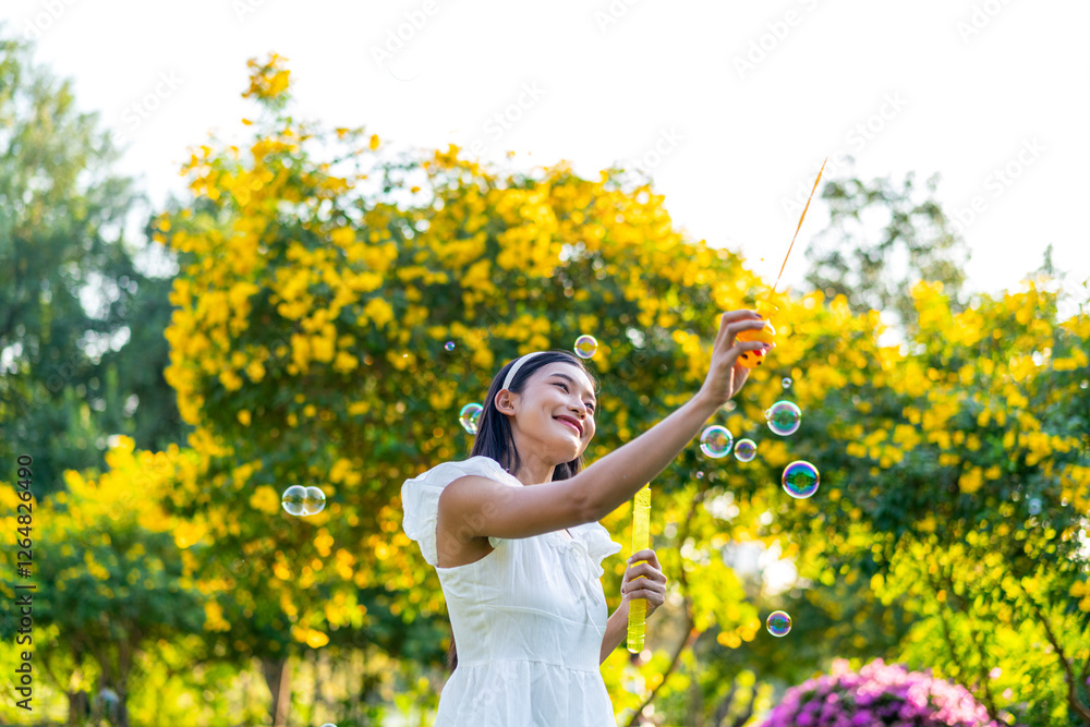 Fototapeta premium Asian Woman Blowing Bubbles in a Park