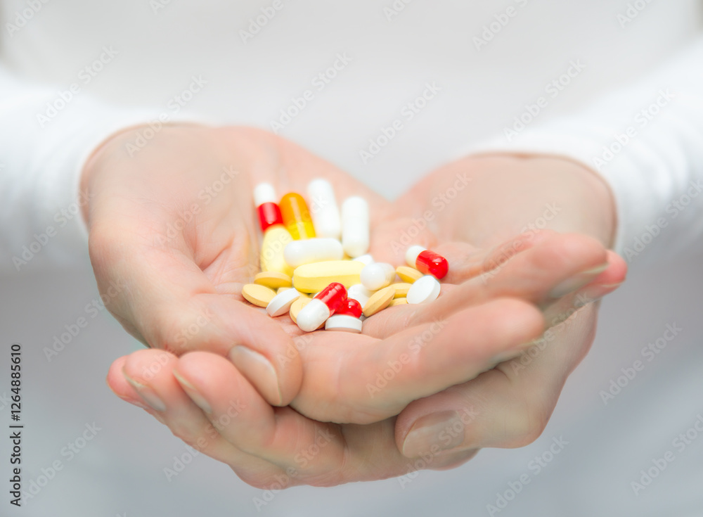 Hands holding various colorful pills in a bright setting during daylight Hands holding various colorful pills in a bright setting during daylight