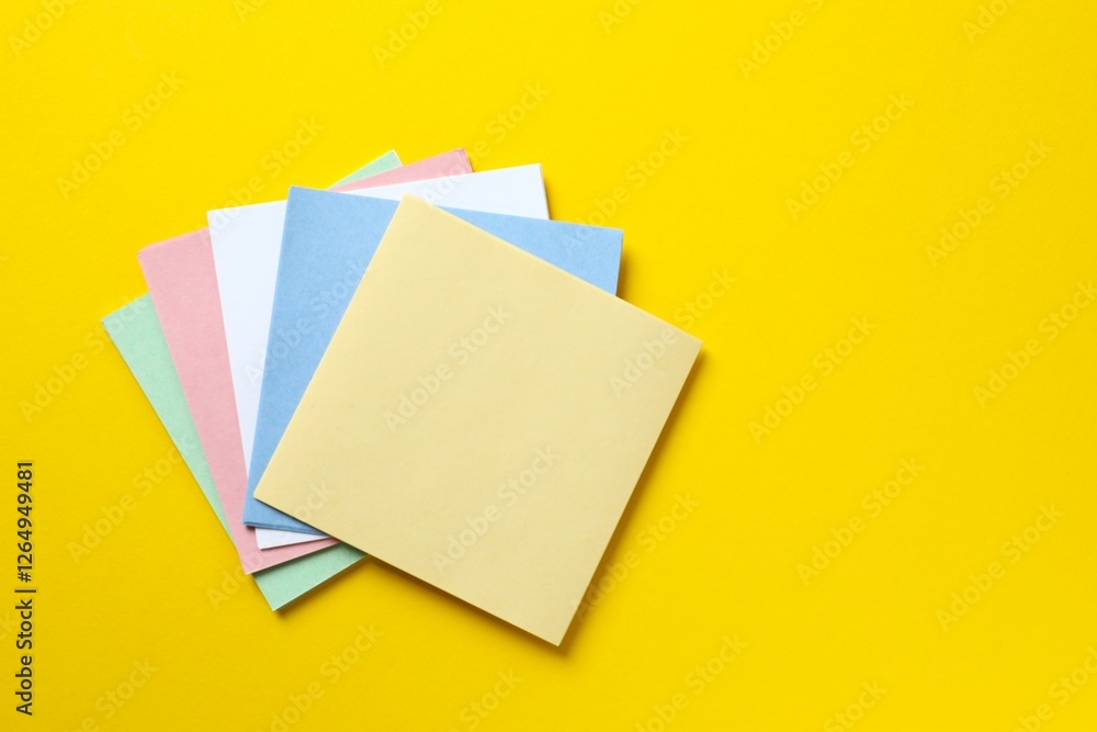 Top view of stacks of colorful sticky notes on color background Top view of stacks of colorful sticky notes on color background