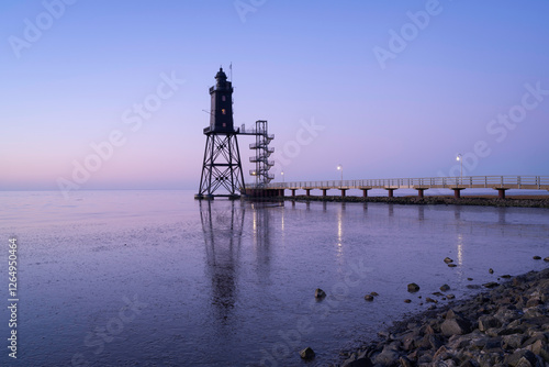 Lighthouse Obereversand at low tide with reflection. photo