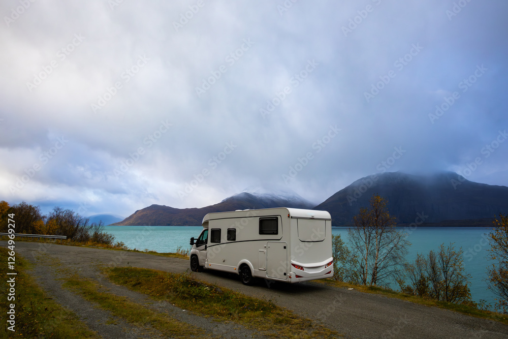 A motorhome parked by the road in the autumn landscape of the Lyngen Alps, Northern Norway, with mountains. A motorhome parked by the road in the autumn landscape of the Lyngen Alps, Northern Norway, with mountains.