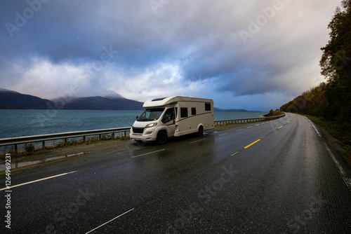 A motorhome parked by the road in the autumn landscape of the Lyngen Alps, Northern Norway, with mountains.