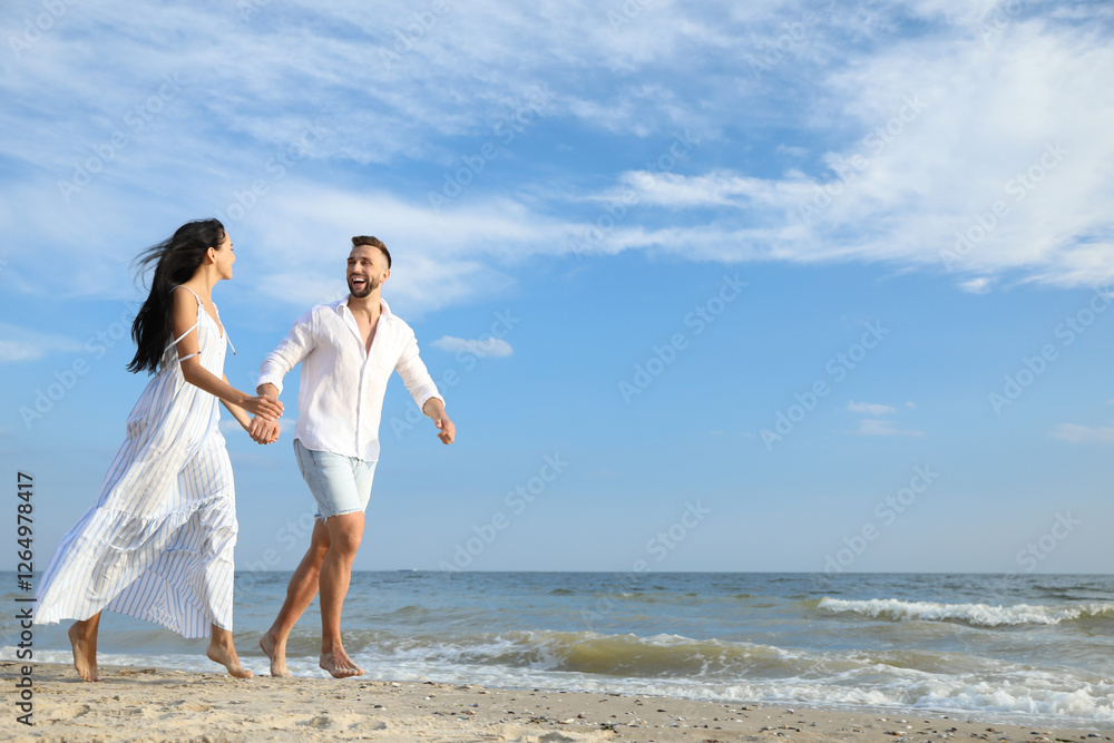 Happy young couple running together on beach Happy young couple running together on beach