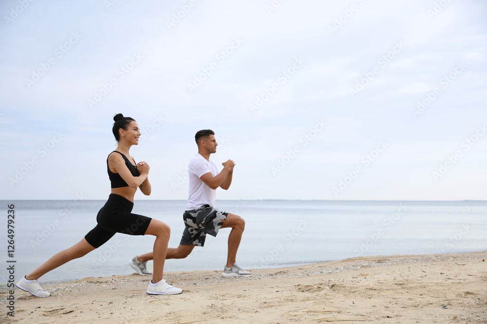 Couple doing exercise together on beach, space for text. Body training Couple doing exercise together on beach, space for text. Body training