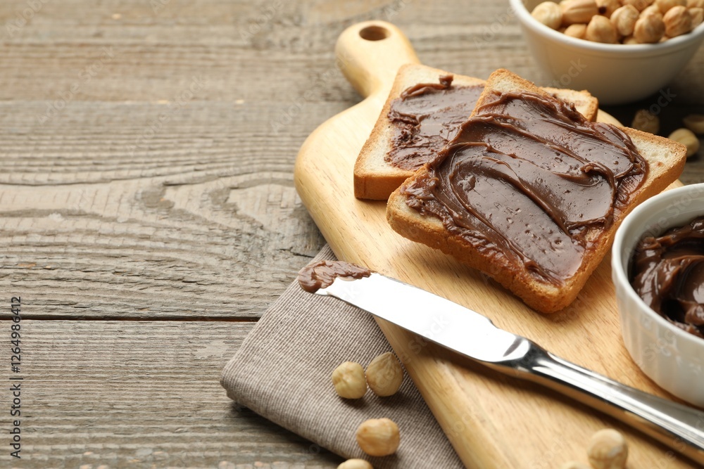 Sandwiches with chocolate butter, hazelnuts and knife on wooden table, closeup. Space for text Sandwiches with chocolate butter, hazelnuts and knife on wooden table, closeup. Space for text
