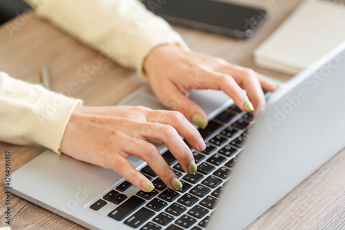 Freelance professional typing on a laptop in her home office, emphasizing focus and productivity. photo