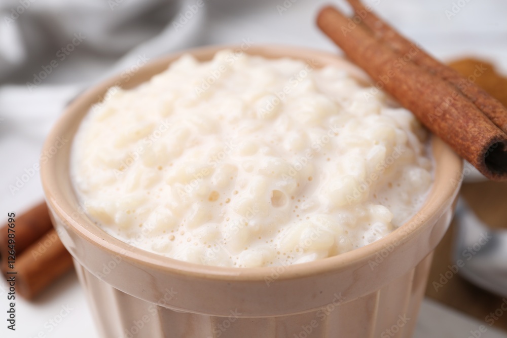 Tasty rice pudding with cinnamon on table, closeup Tasty rice pudding with cinnamon on table, closeup