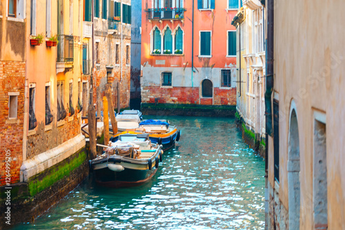 Obraz na płótnie Picturesque canal in Venice, Italy, with colorful buildings lining both sides and several boats moored along waterway. Vibrant hues of buildings and reflections in water capture Venice unique charm w salonie