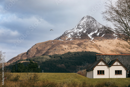 Obraz na płótnie Majestic mountain backdrop with snow and cozy house in picturesque Scottish landscape w salonie