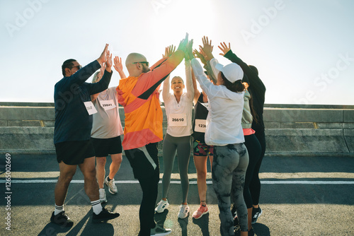 Group of runners cheering and supporting each other outdoors photo