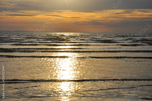 Seascape. Sandy seashore at sunset at low tide
