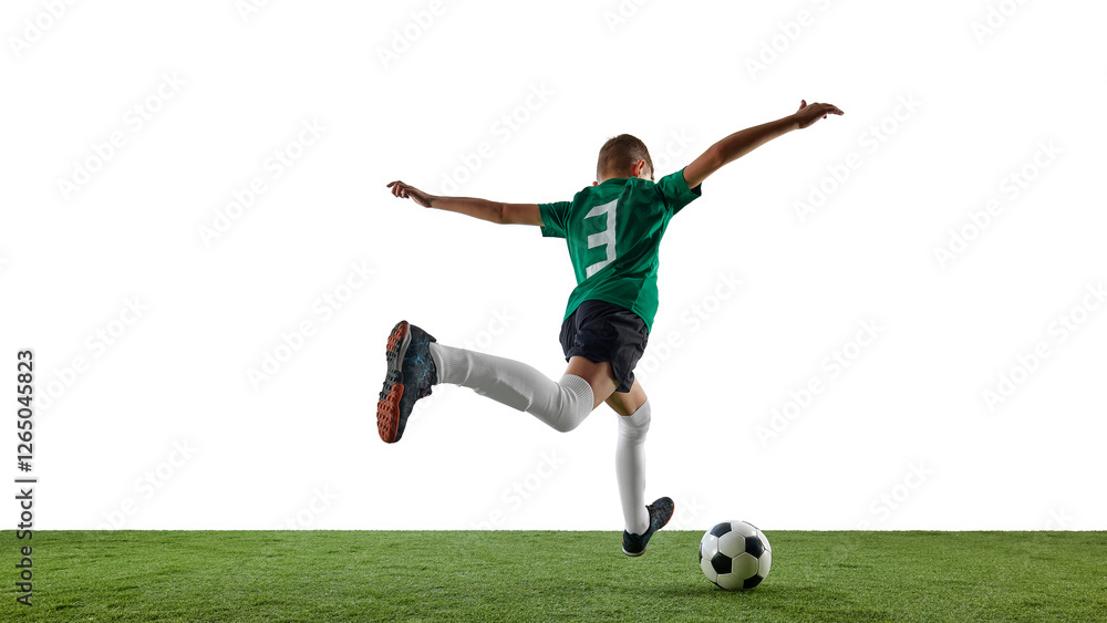 Side view image of teen boy, soccer player in green jersey and black shorts in motion on field, running towards ball against white background. Concept of sport, education, competition, game Side view image of teen boy, soccer player in green jersey and black shorts in motion on field, running towards ball against white background. Concept of sport, education, competition, game