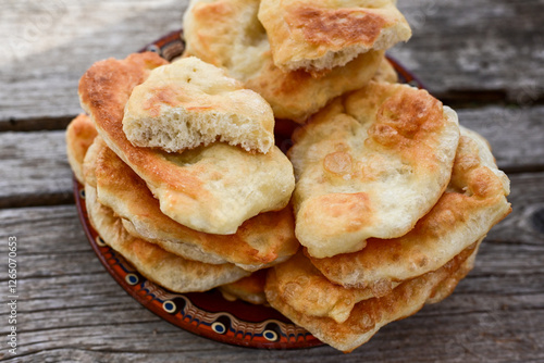 Traditional Bulgarian home made deep fried  patties  covered with sugar  оn rustic backgroud.Mekitsa or Mekica,  on wooden  rustic  background. Made of kneaded dough that is deep fried  photo