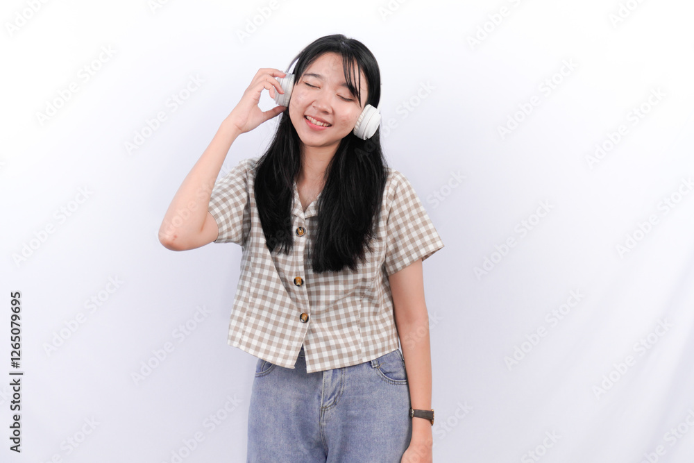 Asian Indonesian woman wearing a white checkered shirt wearing a headset listening to music